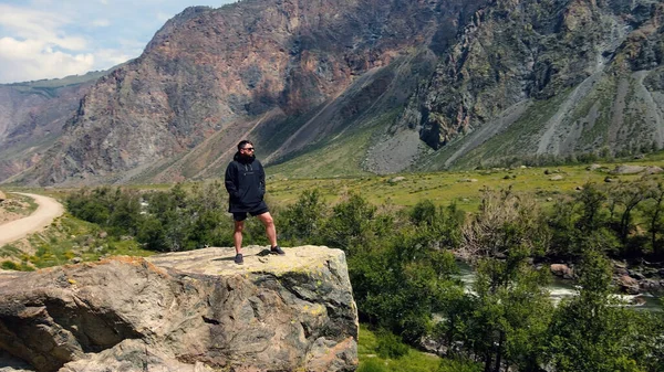 Ein Mann steht am Rande einer Klippe und trägt einen schwarzen Anorak. Katu-Yaryk Schlucht Chulyshman Valley. Altai — Stockfoto