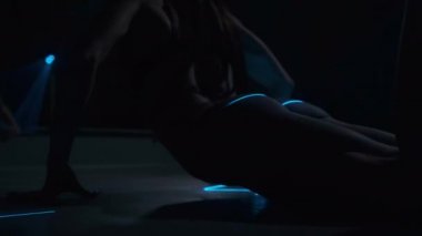 The girl bends against the background of smoke and a laser. Athletic figure, beautiful ass. Sexuality.