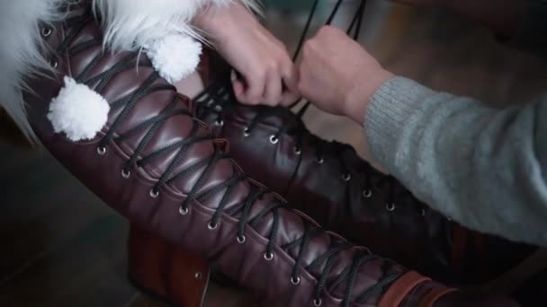 They lace up a burgundy boot in two hands, the girl helps. — Stock Video