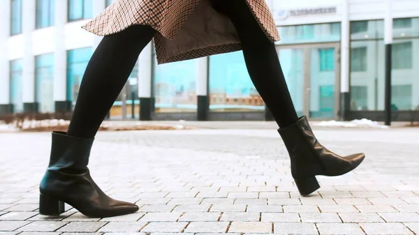 Närbild skor ben affärskvinna promenader i modern stad bråttom. Affärsidé. Asiatisk hieroglyf på trottoaren Stockfoto