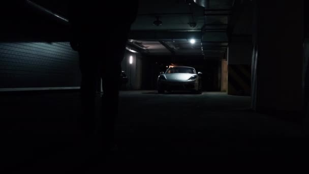 2020年12月12日:シルバーポルシェ718ボクスターは、駐車場のリアライトのクローズアップに立っている。車の中に男が来て手をバンプの上に走らせ — ストック動画