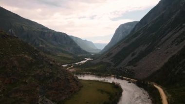 Vadideki dağların arasından nehrin üzerinden uçuyor. Altai.