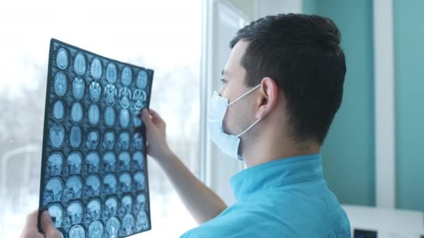Γιατρός κοιτάζοντας μαγνητικές τομογραφίες του εγκεφάλου — Αρχείο Βίντεο