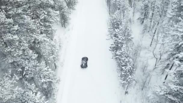 モスクワ、ロシア- 13 12月2020:黒高級スポーツカーは冬に雪の森の中で漂流しています。ドローンビュー — ストック動画