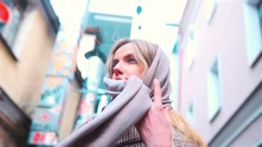 A girl of Slavic appearance wraps a scarf around her neck in the Japanese quarter