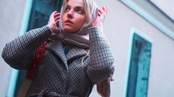 A girl of Slavic appearance wraps a scarf around her neck in the Japanese quarter — Stok video