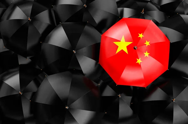 Umbrella with Chinese flag among black umbrellas, top view. 3D rendering