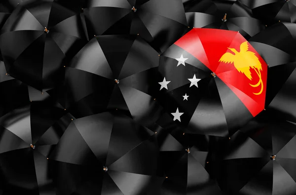 伞形与巴布亚新几内亚国旗之间的黑色雨伞 顶部视图 3D渲染 — 图库照片