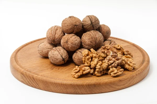 Орехи на деревянной пластине — стоковое фото