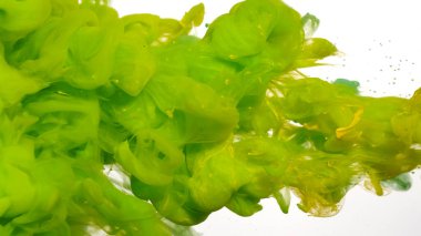 Soyut arkaplan. Suda yeşil ve sarı mürekkep damlaları. Suda renkli akrilik boya. Beyaz zemin üzerinde yeşil ve sarı suluboya mürekkep. Beyaz arkaplanda yeşil mürekkep bulutu.