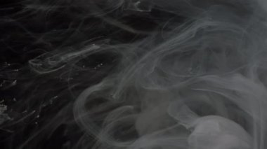 Beyaz ve siyah soyut arka plan. Mürekkep yavaş akıyor. Siyah arka planda suya karıştırılmış beyaz ve siyah suluboya mürekkep. Ekran Koruyucu.