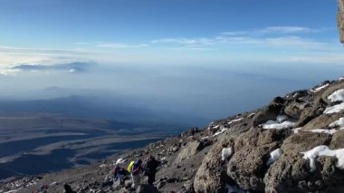 Kilimanjaro Dağı 'ndan muhteşem bir manzara. Aralık ayında Kilimanjaro 'ya tırmanan çok sayıda turist dağa tırmandı. Bulutlardaki Mawenzi Dağı manzarası.