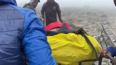 Kilimanjaro, Tanzanya - 1 Ocak 2022: Siyahiler yaralı bir kişiyi kampa nakledilmesi için hazırlıyorlar. Kilimanjaro 'ya tırmanmak. Afrika 'da Seyahat.