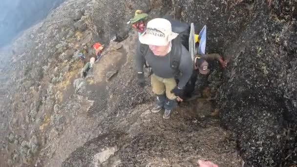 タンザニアのキリマンジャロ 2021年12月30日 1人のハイカーが2番目に大きな岩を登るのを助けます 一人称視点 バランコの壁 山の風景 クライミングキリマンジャロ — ストック動画