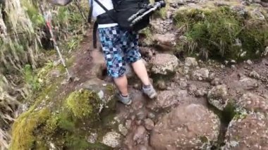 Kilimanjaro, Tanzanya - 27 Aralık 2021: İki yürüyüşçü kayalık bir dağ yolunda yürüyor. Bacak manzarası. Kilimanjaro 'ya tırmanmak.