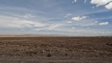 Afrika 'nın çöl arazileri güneş tarafından kavruldu. Tanzanya 'nın uçsuz bucaksız genişliğinin panoraması. Afrika doğası. Dağlar, tepeler, mavi gökyüzü ve beyaz bulutlar.