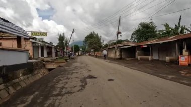 Arusha, Tanzanya - 25 Aralık 2021: Arusha şehrinin caddelerinden birinde yürüyüş. Yerel polis geçiyor, motosikletliler ve arabalar geçiyor..