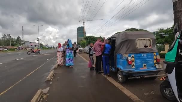 タンザニアのアーシャ 2021年12月25日 アーシャの街の一つの歩道を歩く カラフルな地元の人々 オートバイ 公共交通機関の停留所 — ストック動画