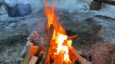 Burning firewood and logs. Yellow-orange flames. A beautiful blazing fire. Hiking life. Winter hike.