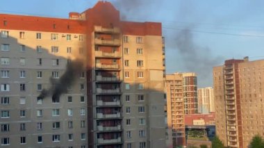 Fire in an apartment building. Black smoke billows from the windows of the apartment. Extinguishing a fire in a high-rise building.