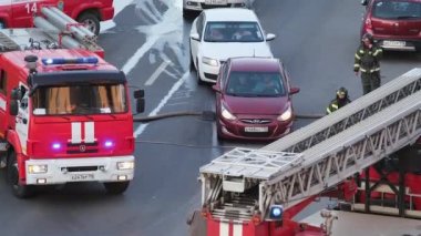 St. Petersburg, Russia - June 28, 2022: Cars run over a fire hose one after another. Traffic jam due to fire.