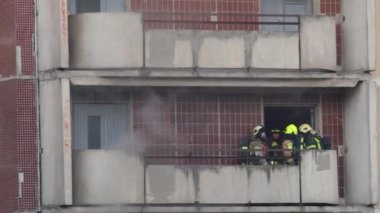 St. Petersburg, Russia - June 28, 2022: A group of firefighters stand on the balcony of an apartment building and discuss an action plan. Extinguishing a fire in a high-rise building.