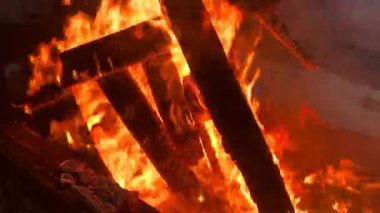 Pieces of wood are on fire. Infernal yellow-orange flames. Burning wood. A beautiful blazing fire.