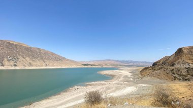 Amazing view of a beautiful mountain lake. Rocky mountains and hills of Kyrgyzstan. Calming natural background.