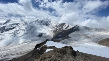 Snow-covered mountain peaks of the Pamirs. Beautiful mountain landscape. Rocky mountains under Lenin Peak. The amazing nature of Kyrgyzstan.