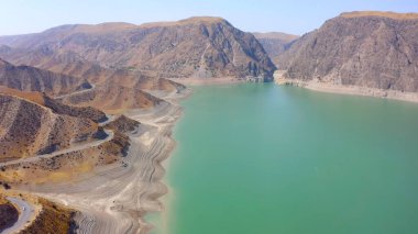 Aerial view of a beautiful green-blue mountain lake. Amazing natural background. Rocky mountains, hills and slopes of Kyrgyzstan.