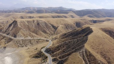 Beautiful mountains, hills and slopes of Kyrgyzstan. Aerial view of the mountain road. Amazing natural background. Summer mountain landscape.