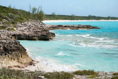 Half Moon Cay 'de kayalık bir kıyı şeridi ve turist plajı manzarası (Bahamalar)).