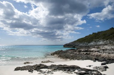 Yarım Ay Geçidi 'ndeki kumlu sahil ve kayalık kıyı şeridi üzerinde kara bulutlar.).