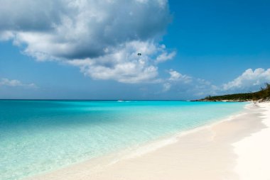 Half Moon Cay Adası plajı boyunca (Bahamalar) deniz paraşütü aktivitesinin manzarası).