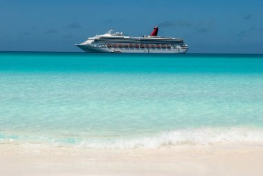 Yarım Ay Cay plajındaki turkuaz renkli su manzarası ve arka planda sürüklenen bir yolcu gemisi (Bahamalar)).