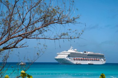 Half Moon Cay turist plaj suları ve arka planda sürüklenen bir yolcu gemisi manzarası (Bahamalar).