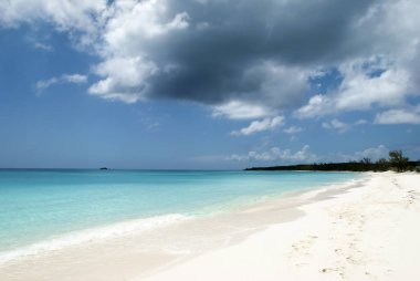 The dark cloud over an empty beach on Half Moon Cay uninhabited island (Bahamas).