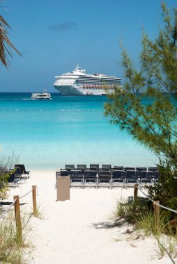 Sürüklenen bir yolcu gemisinin manzarası ve diğer adıyla ıssız bir ada olan Half Moon Cay 'de bir turist plajı (Bahamalar).).