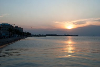 Nassau Limanı üzerindeki turuncu gün batımı ve şehir merkezindeki Nassau rıhtımı (Bahamalar)).