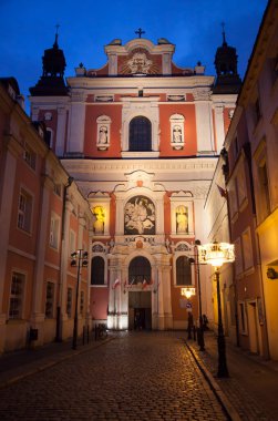 Olomouc 'ta (Çek Cumhuriyeti) arka planda bir kilisenin bulunduğu dar bir caddenin gece görüşü).