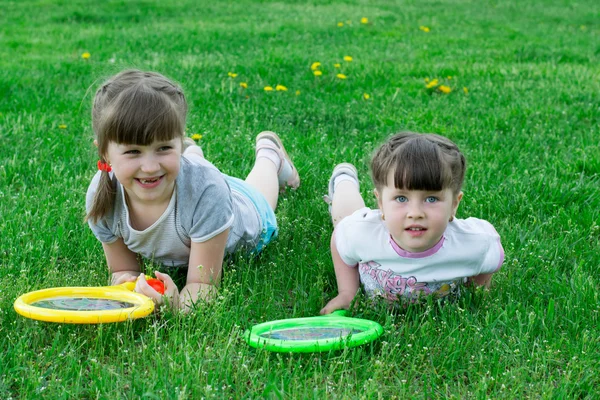 Two little girls on the grass with rackets — Stock Photo, Image