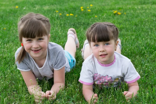 Twee kleine meisjes op het gras — Stockfoto