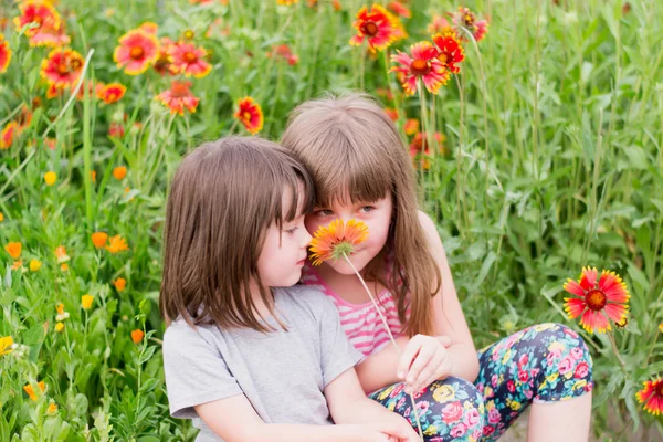 Two small children with flowers — Stock Photo, Image