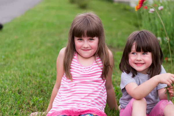 Twee kleine kinderen met bloemen — Stockfoto