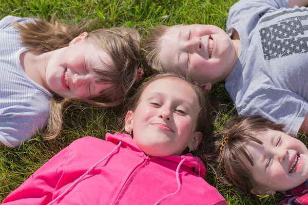 Quatre enfants sur l'herbe, à l'extérieur — 图库照片