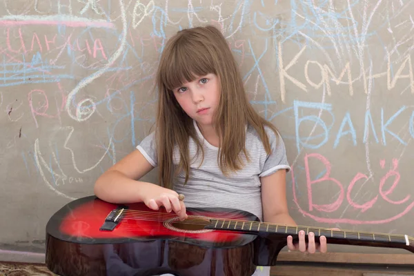 Girl 6-7 years old, sitting with a guitar — Stock Photo, Image