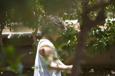 Çalılıkların arasında oynayan kız