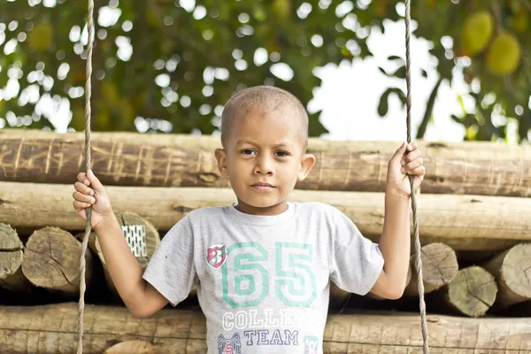 Pojken står över swing — Stockfoto