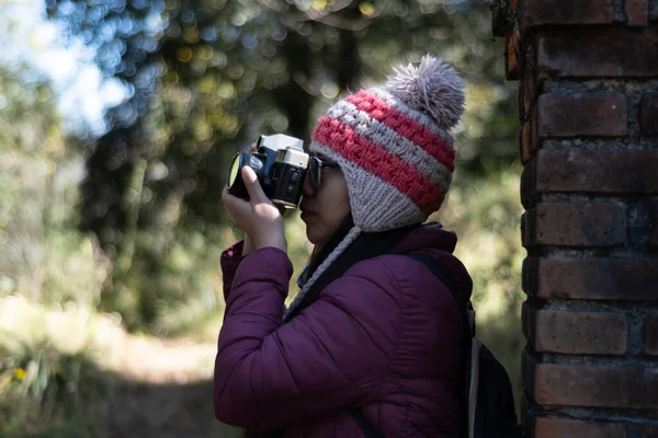 Doğanın ortasında kamera kullanan genç bir kadın.