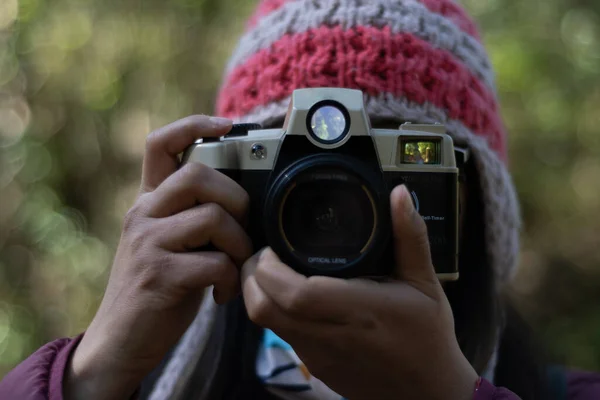 Doğanın ortasında kamera kullanan genç bir kadın.